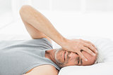 Smiling mature man resting in bed