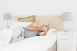 Mature man suffering from cold in bed