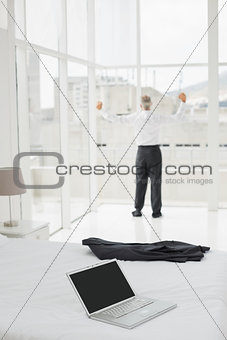 Businessman looking through window at a hotel bedroom