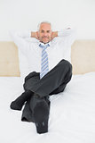 Portrait of a relaxed mature businessman sitting in bed