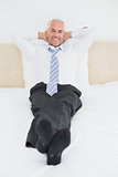 Relaxed mature businessman sitting in bed