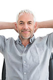Relaxed mature businessman with hands behind head