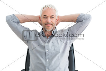 Relaxed mature businessman with hands behind head