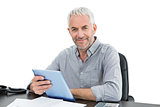 Portrait of a mature businessman with digital tablet at desk