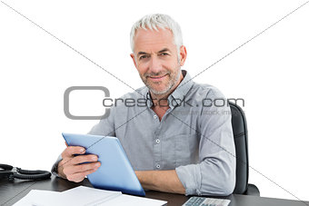 Portrait of a mature businessman with digital tablet at desk