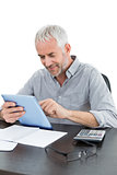 Mature businessman with digital tablet and calculator at desk