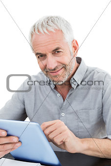 Portrait of a smiling mature businessman using digital tablet