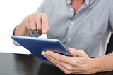 Mid section of a businessman using digital tablet at table