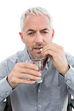 Close-up of a mature man with glass of water and pill