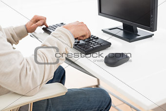 Side view mid section of a man using computer keyboard