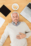 Man sleeping with electronics and biscuits on parquet floor