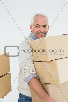 Portrait of a smiling mature man carrying boxes