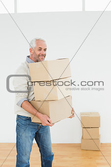 Mature man carrying boxes in a house