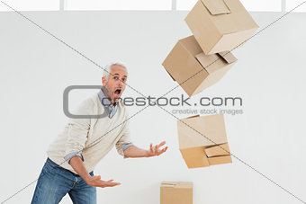 Side view of a mature man with falling boxes