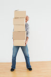 Mature man carrying boxes in a new house