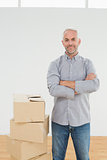 Smiling mature man with boxes in a new house