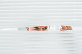 Serious mature businessman peeking through blinds