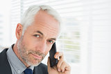 Close-up of a serious mature businessman using cellphone
