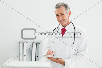 Male doctor writing a report at medical office