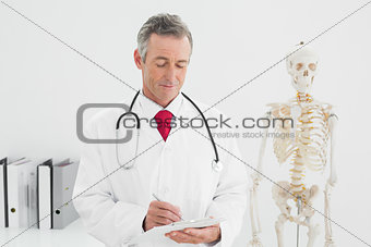 Doctor writing a report at office