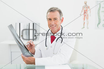 Smiling doctor with x-ray picture of lungs in office