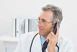 Male doctor using telephone at office
