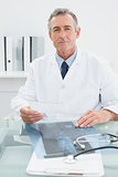 Confident male doctor sitting in office