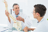 Doctor explaining spine to a patient in office