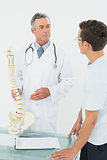 Doctor explaining the spine to patient in office
