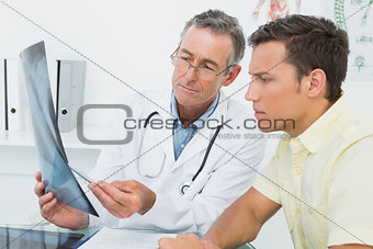 Doctor explaining lungs x-ray to patient in office