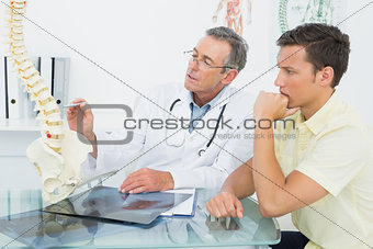 Doctor explaining spine to a patient in office