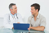 Doctor discussing reports with patient in office