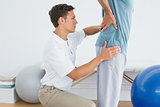 Therapist massaging mans lower back at hospital gym