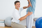 Male therapist massaging mans lower back at gym hospital