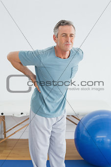 Man with lower back pain in the hospital gym