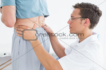Male therapist massaging mans lower back in gym hospital