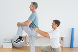 Therapist massaging mans lower back in gym hospital