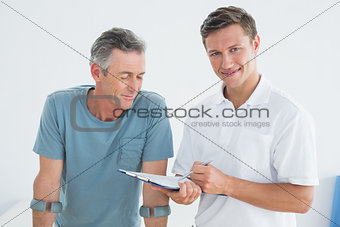 Therapist discussing reports with a disabled patient