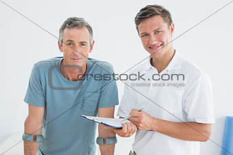 Male therapist and disabled patient with reports