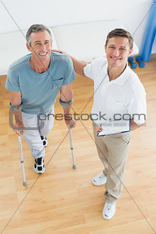 Therapist and disabled patient with reports in gym hospital