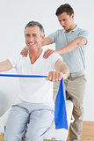 Therapist massaging a mans shoulder in gym hospital