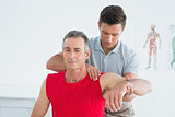 Male physiotherapist stretching a mature mans arm