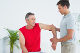 Male physiotherapist stretching a mature mans arm