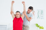 Male physiotherapist stretching a mature mans arms