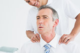 Chiropractor massaging patients neck