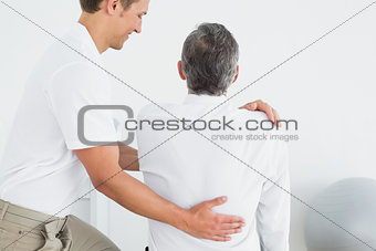 Male chiropractor examining man