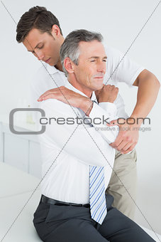 <ale chiropractor examining mature man