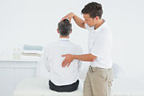 Male chiropractor examining mature man