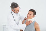 Doctor examining a patients neck in office