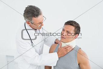 Doctor examining a patients neck in office